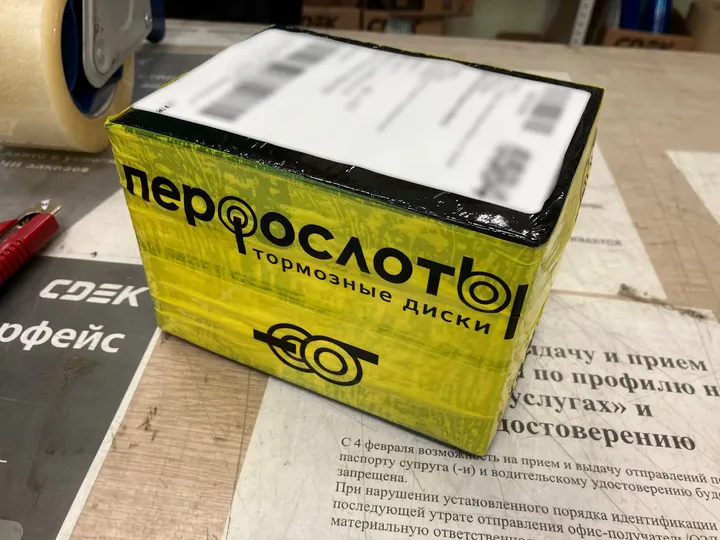 Коробка заказа, обмотанная фирменным жёлто-чёрным скотчем «Перфослоты»